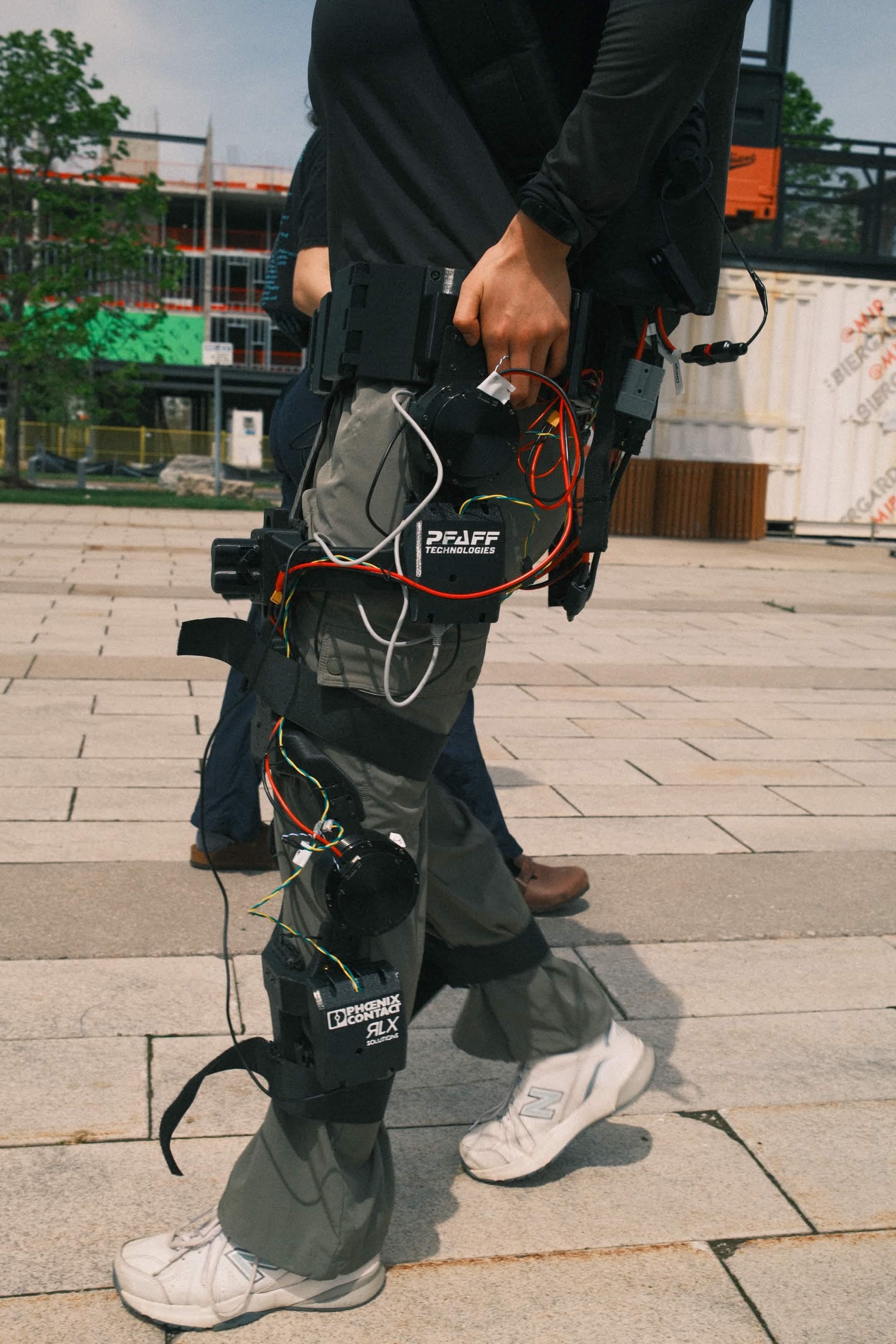 The McMaster exoskeleton worn by a pilot, showing its waist electronics, wiring and powered leg joints.